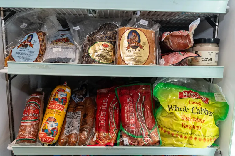 Teodora pork loin, Kraški vrat and govedja pršuta above Hungarian salami, Pik parizer, Bende smoked sausage and whole sour cabbage in the WYN MKT deli fridge