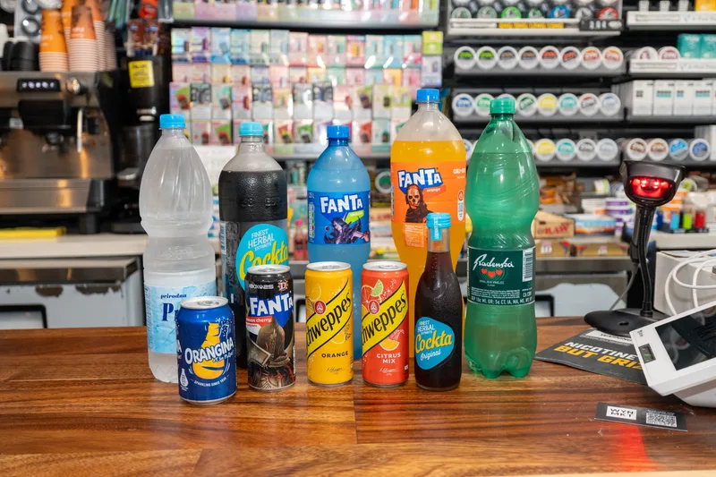 Cockta, Orangina, Fanta, Schweppes and bottled water lined up on the WYN MKT counter